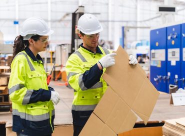 Professional worker team supervisor inspector in packaging stock at cardboard factory warehouse Professional worker team in safety uniform, supervisor inspector in packaging stock order at cardboard factory warehouse, piles of stacking paper manufacture, recycling industrial production